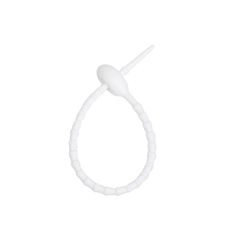 Tadpole silicone tie looped around a wrist to show how flexible the strap is