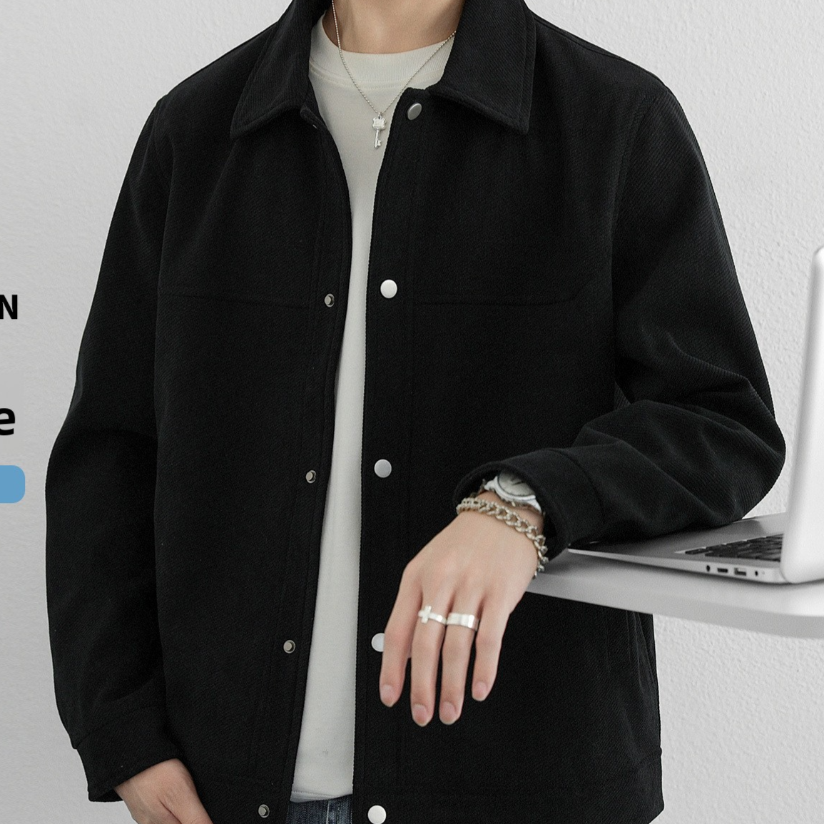 Black button front jacket with a turn down collar, option photo for size M, worn with a watch and a ring