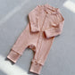 Baby Pink zip front baby romper laid flat on a gray floor, image of the 90 cm, 18 to 24 months size option