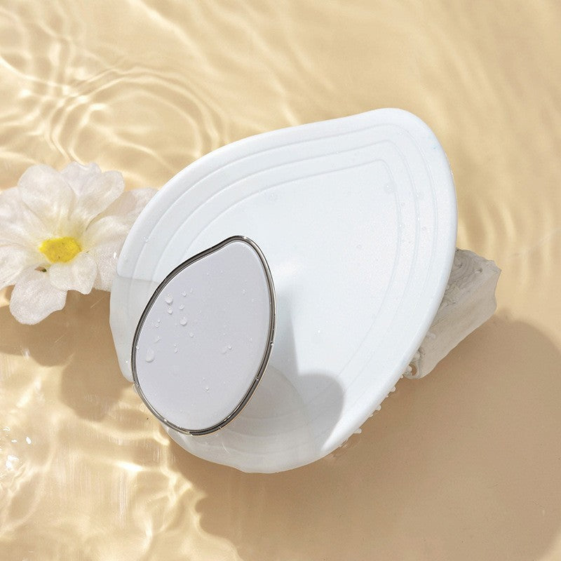Green leaf shaped scalp massage brush shown from the front
