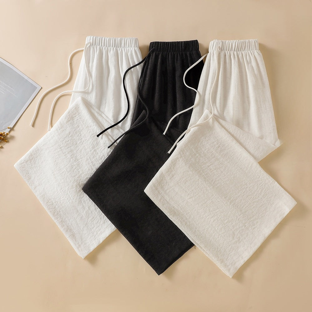 White black and apricot wide leg linen trousers laid side by side