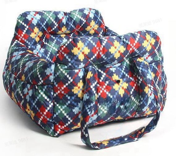 Padded car seat pet bed with raised bolster walls, carry handles and an inner clip top down view into the padded nest