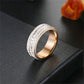 Rose gold tone three row cubic zirconia band ring on a black surface, size No. 13 option