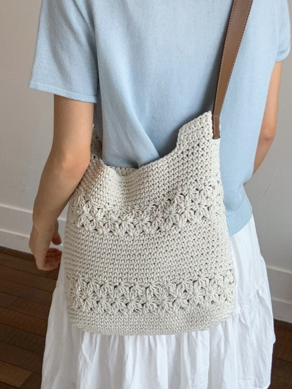 Off-white woven cotton crochet bag worn crossbody with brown strap