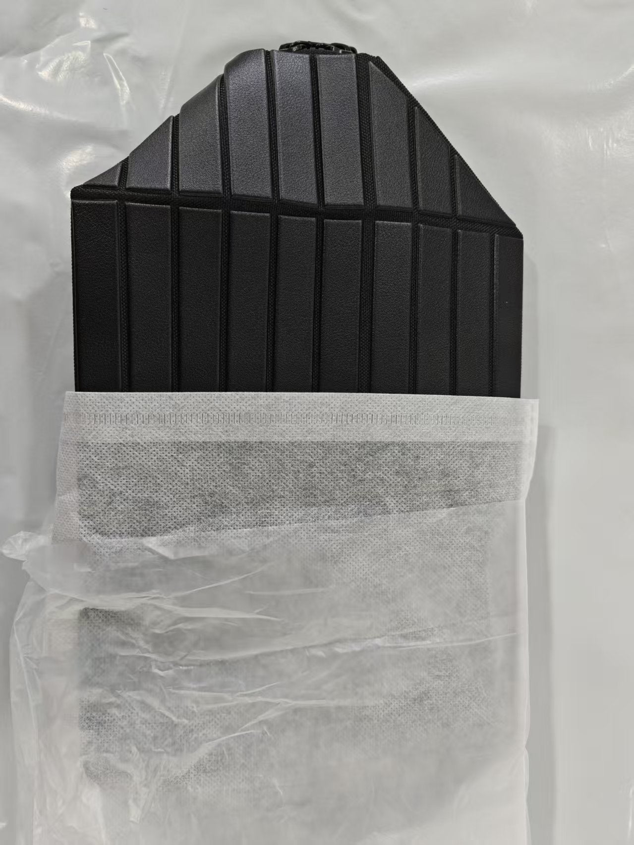 Ribbed stripe makeup organizer bag with a top handle and a wrap around zip on a plain background