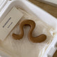 Large wavy acrylic hair claw clip with a strong shark spring on cream tissue