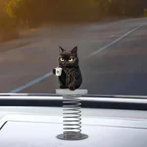 Grumpy black cat on a coil spring mounted on a white car hood with an open road behind
