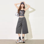 Woman in dark gray cropped wide leg suit pants with belt and sneakers front view