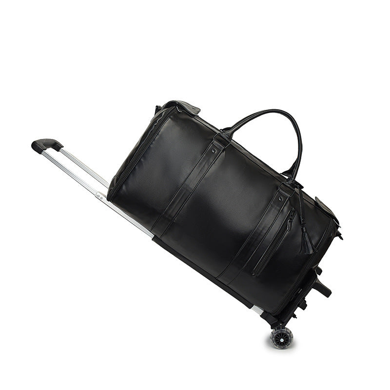 All black duffel travel bag with black straps, two top handles, a telescopic pull rod and two wheels