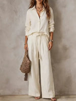 Woman in off white long sleeve shirt and wide leg pants set with braided tie belt, full length