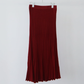 Red ribbed knit skirt with knit waistband hanging on a white hanger