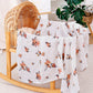Folded cotton muslin swaddle blanket with a soft open weave and an even printed pattern