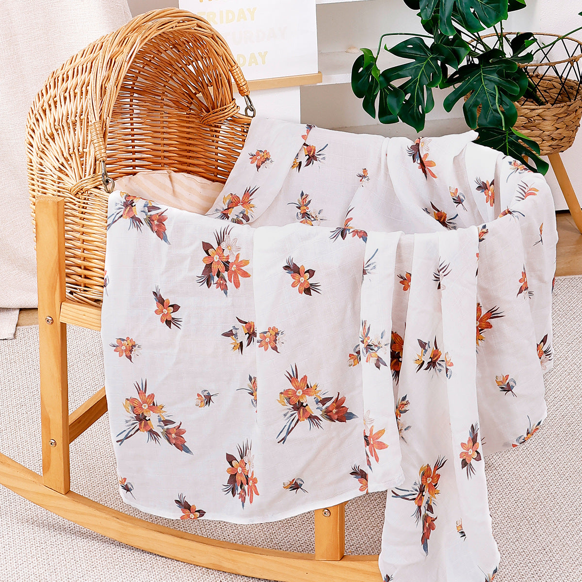 Folded cotton muslin swaddle blanket with a soft open weave and an even printed pattern