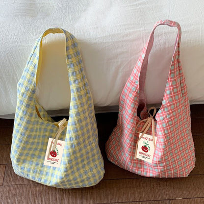 White blue and pink green plaid canvas shoulder bags standing side by side