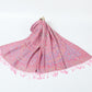 Pink paisley shawl with a lilac and gold border and pink tassels spread on a white background