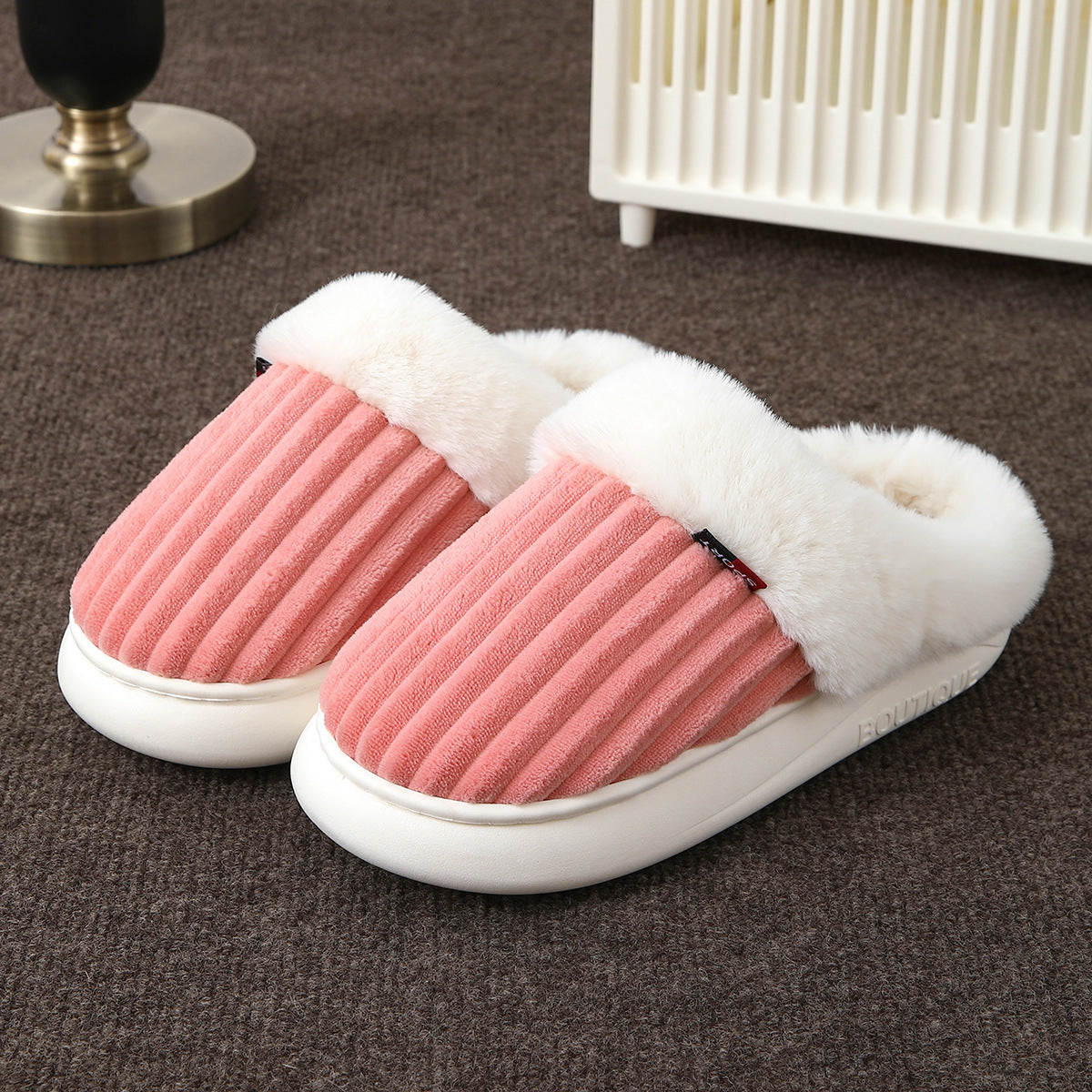 Covered toe indoor mule slippers with a soft plush cuff shown on the floor