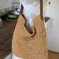 Khaki woven cotton shoulder bag carried by a woman in white