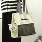 Gray cat carrier tote carried on the shoulder with a cat resting behind the front mesh window