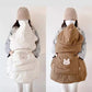 Coffee colored quilted windproof cape over a baby carrier with animal pocket