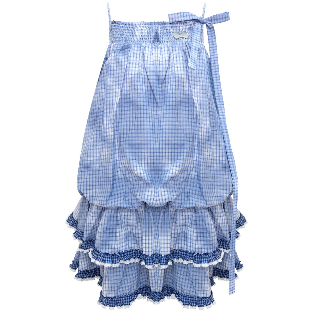 Blue plaid suspender dress worn over a white tee on a sunlit lawn