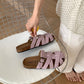 Woven slide sandal held in hand for size scale reference