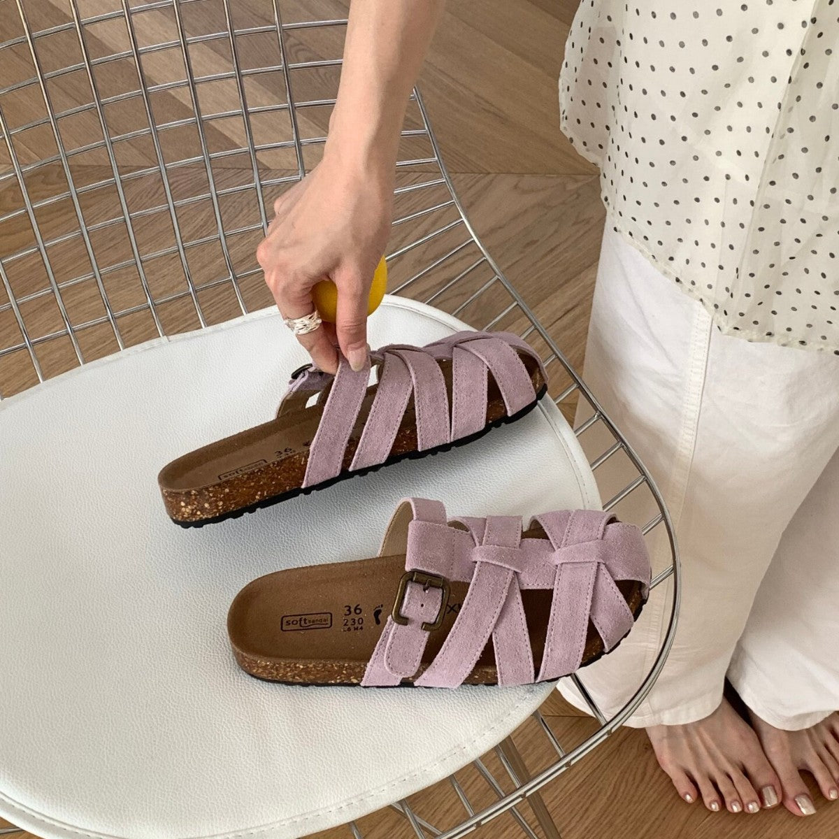 Woven slide sandal held in hand for size scale reference