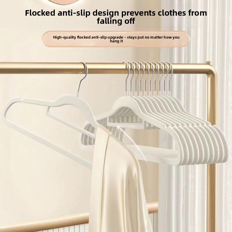 Off-white flocked hangers on a gold rail holding a cream satin garment, anti-slip text overlay