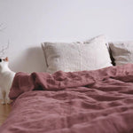 Washed pure linen duvet cover styled on a made bed in a calm minimal bedroom