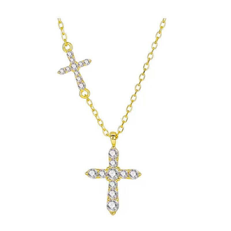 Gold tone sterling silver double cross necklace laid flat on a light background