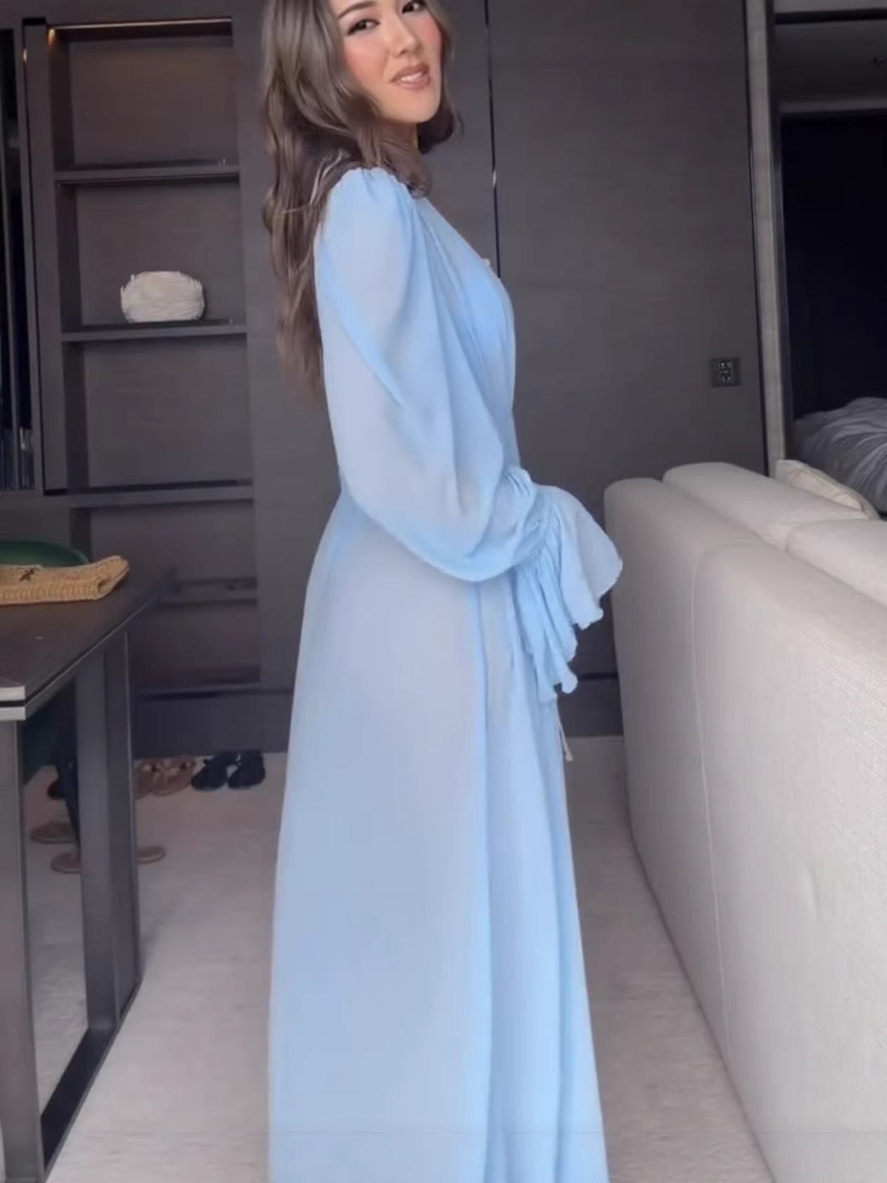 Side view of the floor length light blue chiffon robe showing sleeve drape and full length panels