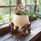 Smiling face rocking chair resin planter shown empty without any plants