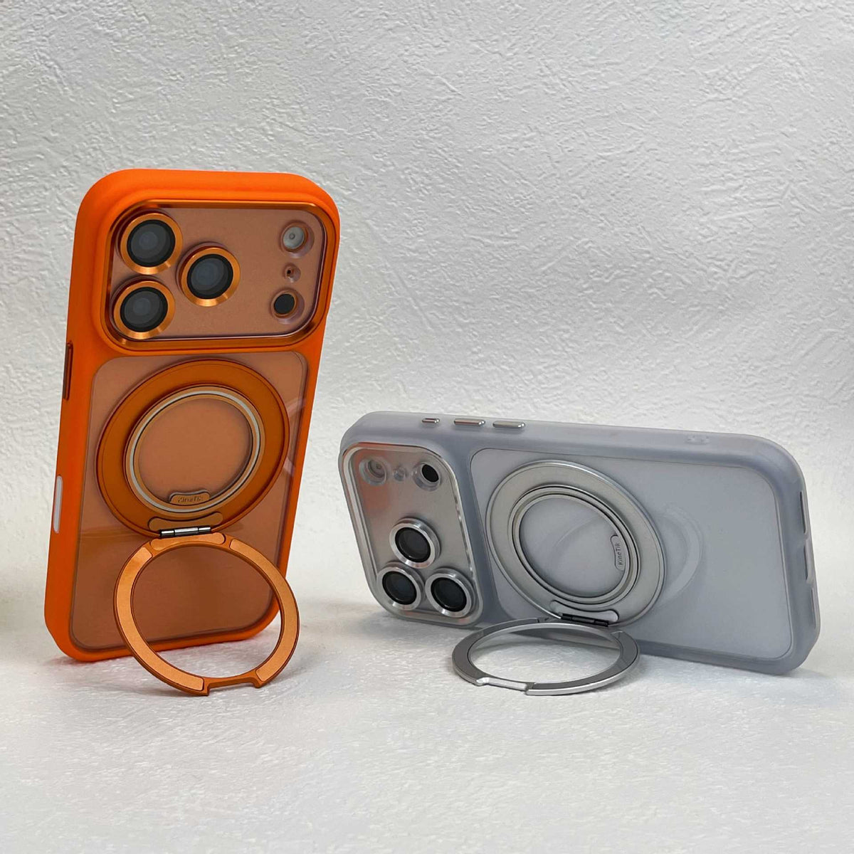 Orange and frosted clear phone cases side by side, each standing on its folded-out ring stand