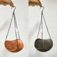 Hanging wooden bird bath swaying from maple branch