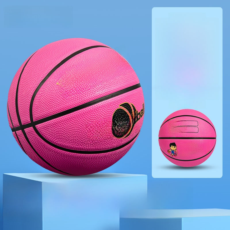 Pink kids basketball with deep black seam lines on a studio pedestal