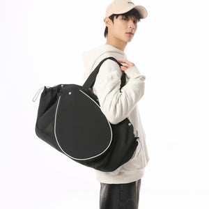 Man carrying the black racket-front sports bag on his shoulder by the top handles