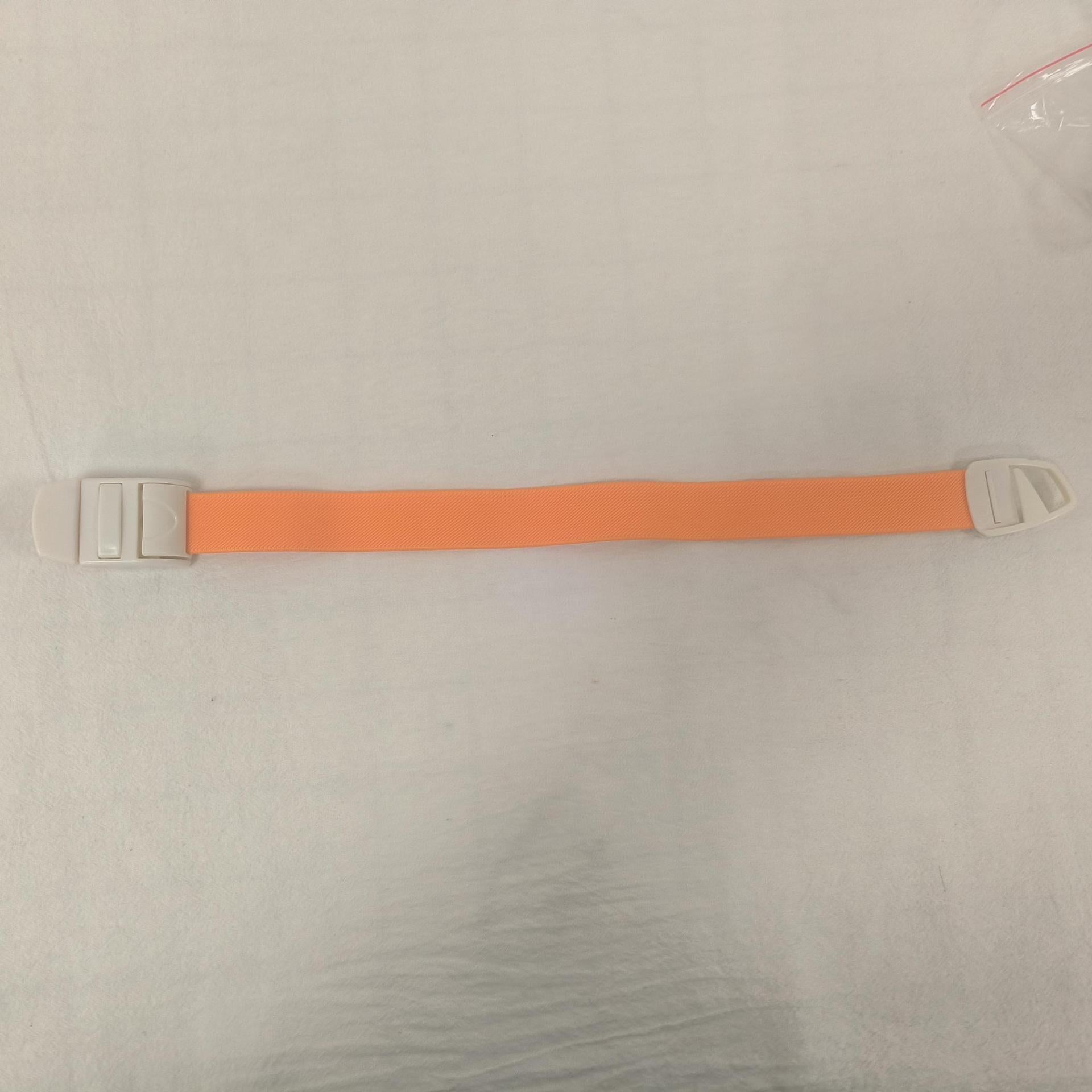 Single orange elastic quick release tourniquet band with a white snap buckle laid flat