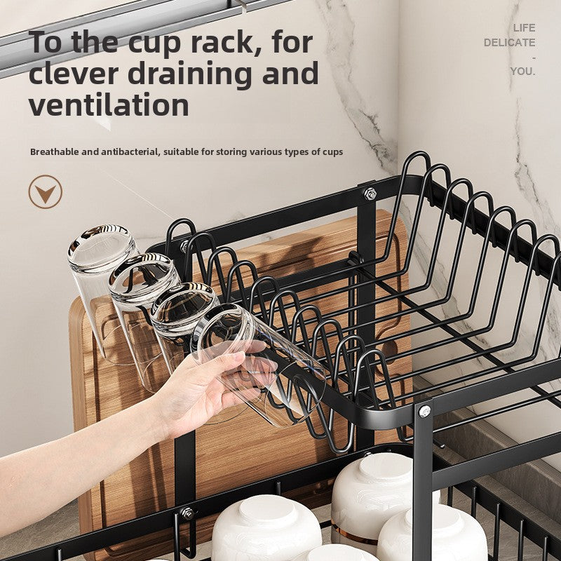 Hand placing a glass upside down on the cup rack of a black double layer dish rack