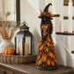 Yellow variant: witch statue in a yellow and orange leaf gown beside a lantern and a pumpkin