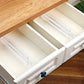 Clear drawer dividers separating folded shirts and rolled socks inside a wooden drawer