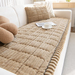 Camel quilted plush sofa cover with a scalloped edge on a cream sofa, cup and magazine on top