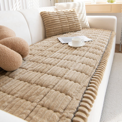 Camel quilted plush sofa cover with a scalloped edge on a cream sofa, cup and magazine on top