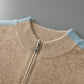 Close view of a ribbed collar and metal zipper pull on a camel wool cardigan with light blue trim