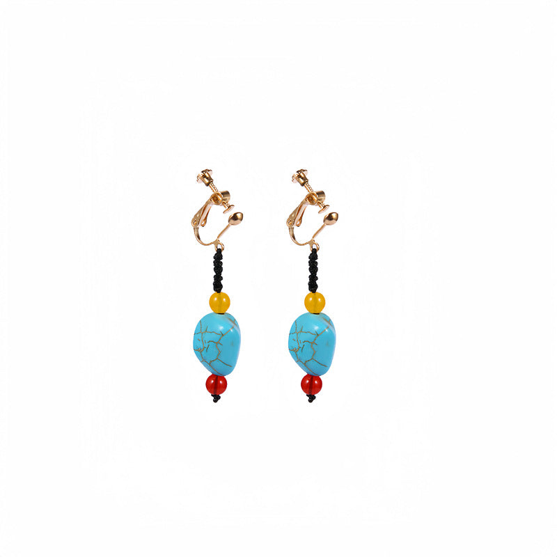 Handmade bohemian clip-on earrings with tassel and bead drop detail, zinc alloy frame, studio shot on white background