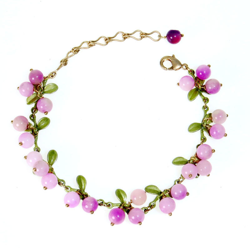 Pink berry cluster charm bracelet with enamel leaves and a lobster clasp shown on a wrist