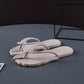 Navy flip flops unfolded flat next to the folded pair on tile floor