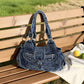 Blue denim hobo shoulder bag with front zip pocket shown on a wooden bench