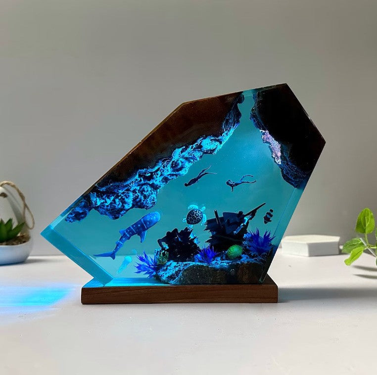 Clear blue resin ocean scene with divers whale shark and shipwreck detail