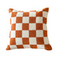 Orange and cream checkerboard plush pillow on a white background