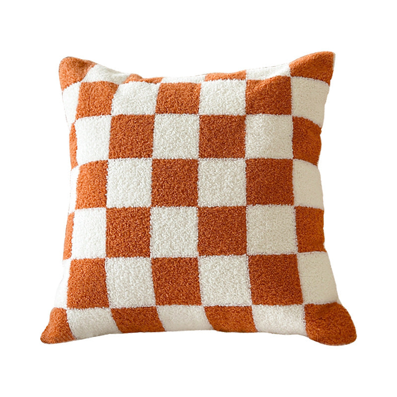 Orange and cream checkerboard plush pillow on a white background