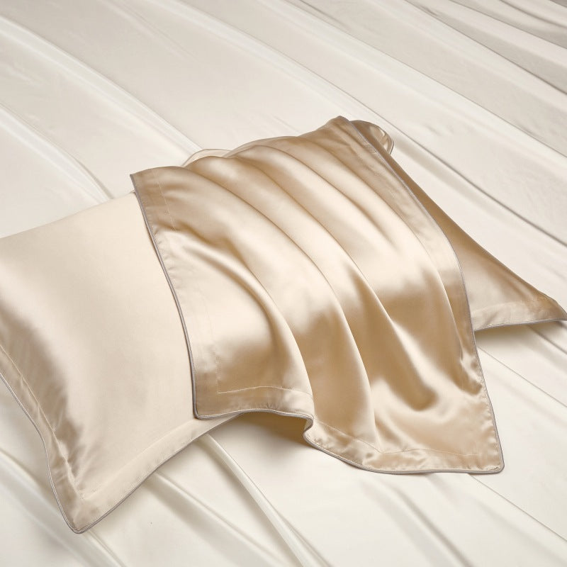 Silk pillowcase draped over a pillow on a smooth white sheet